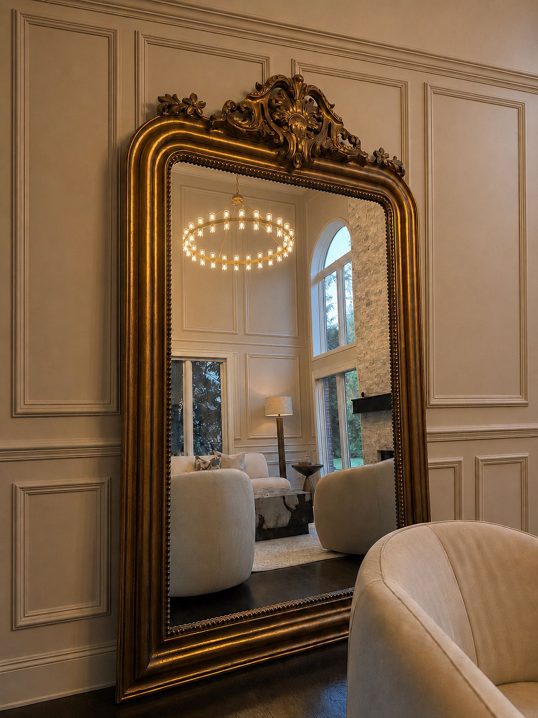 Ornate gold floor mirror reflecting living space
